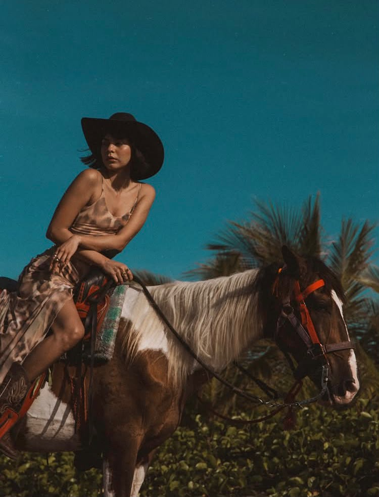 A rider on a pinto horse beneath the blue Surf City sky